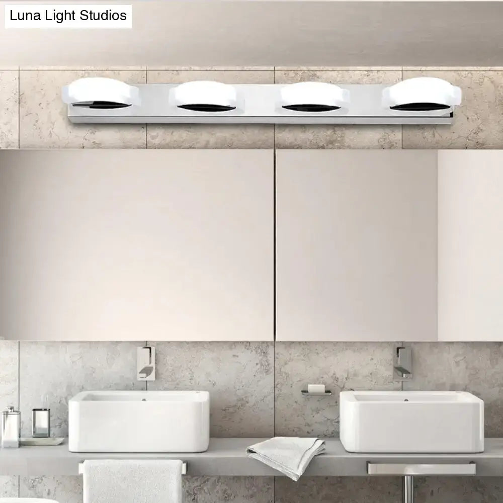 Chrome vanity mirror light with four white shades on a slim bar above a modern bathroom vanity on Tampa Home & Garden Store
