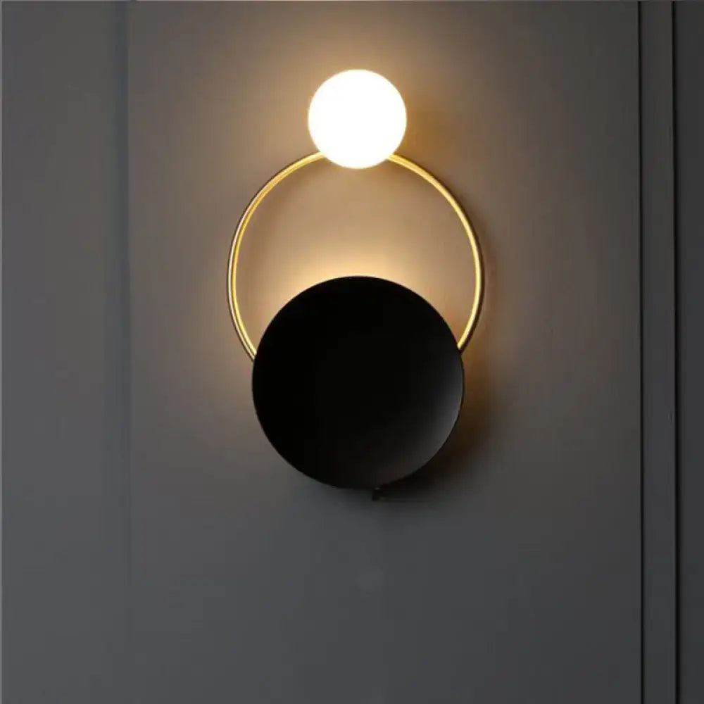 Black brass circle sconce with white globe on gold ring by Decorbites, wall-mounted on Tampa Home & Garden Store