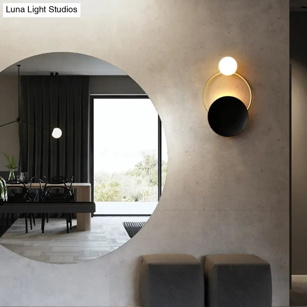 Decorbites black brass circle sconce with gold ring and white globe on textured wall on Tampa Home & Garden Store