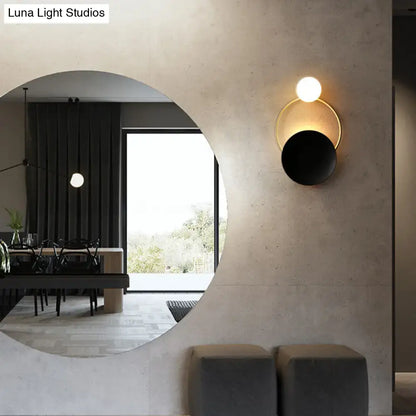 Decorbites black brass circle sconce with gold ring and white globe on textured wall on Tampa Home & Garden Store