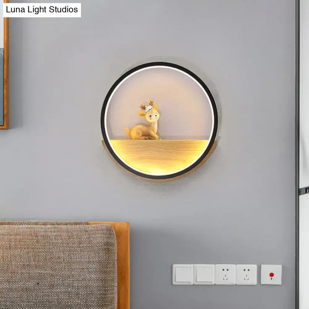 Black circular deer wall light with warm bottom glow and deer figurine inside on Tampa Home & Garden Store