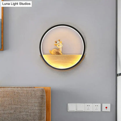 Black circular deer wall light with warm bottom glow and deer figurine inside on Tampa Home & Garden Store