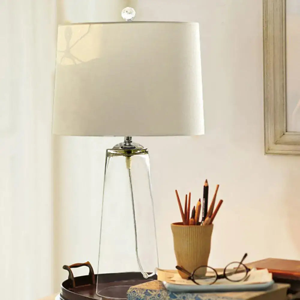 Clear Glass Table Lamp with a tripod glass base and white shade on a dark wood table on Tampa Home & Garden Store