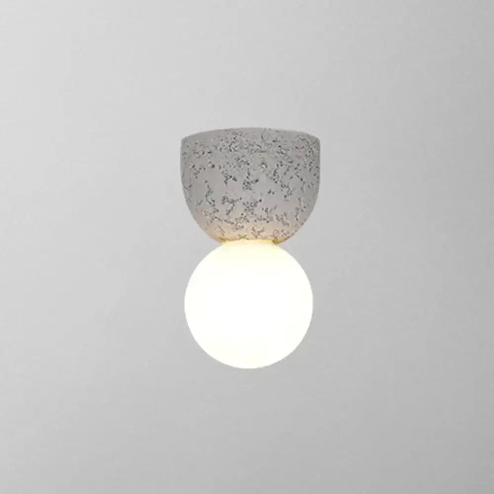 Pink concrete wall sconce with a glowing white globe by Decorbites on Tampa Home & Garden Store