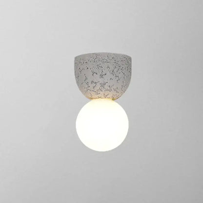 Pink concrete wall sconce with a glowing white globe by Decorbites on Tampa Home & Garden Store