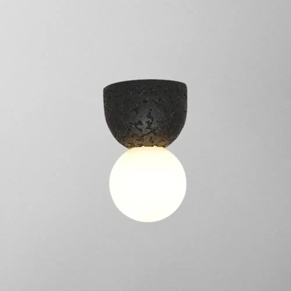 Pink Concrete Wall Sconce with textured dark top and glowing white globe by Decorbites on Tampa Home & Garden Store