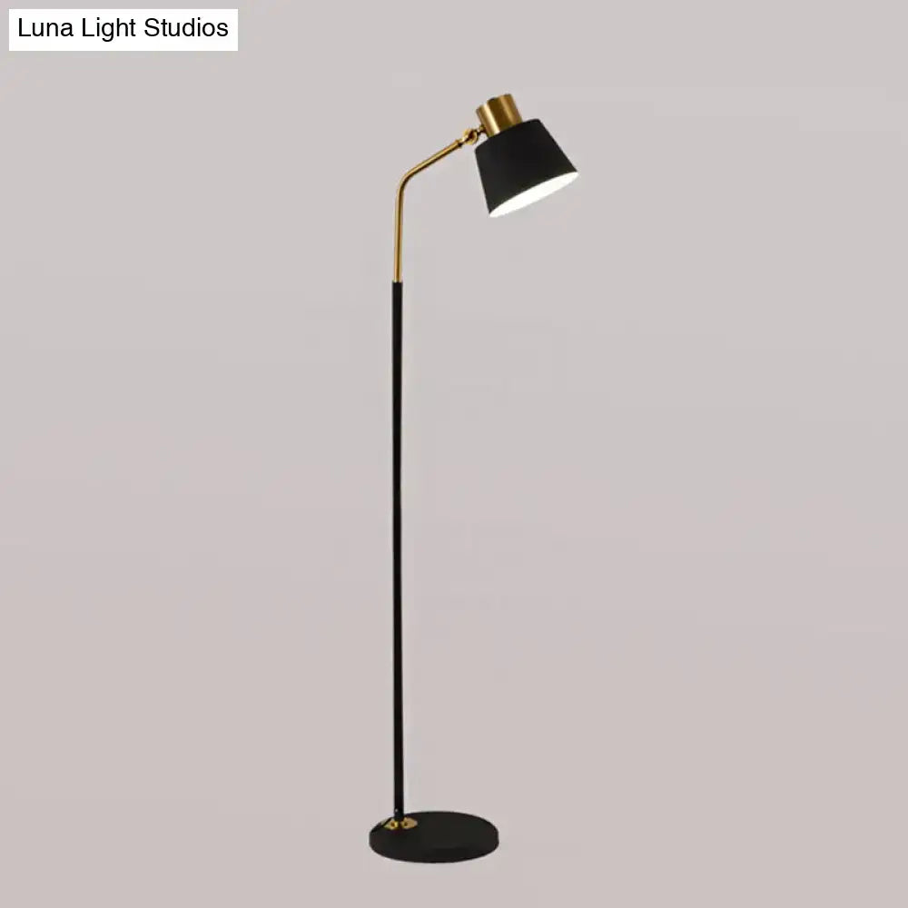 Floor lamp with black shade, gold arc and slender black stem, round base on Tampa Home & Garden Store