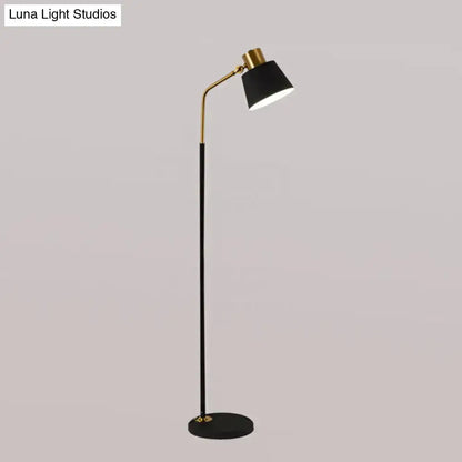 Floor lamp with black shade, gold arc and slender black stem, round base on Tampa Home & Garden Store