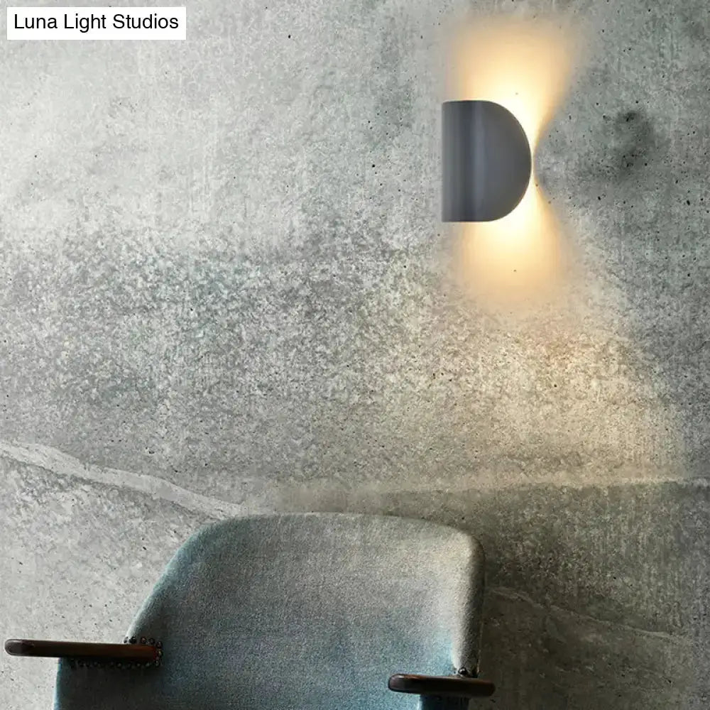 Modern curved wall sconce light by Decorbites with warm ambient glow on concrete bedroom wall on Tampa Home & Garden Store