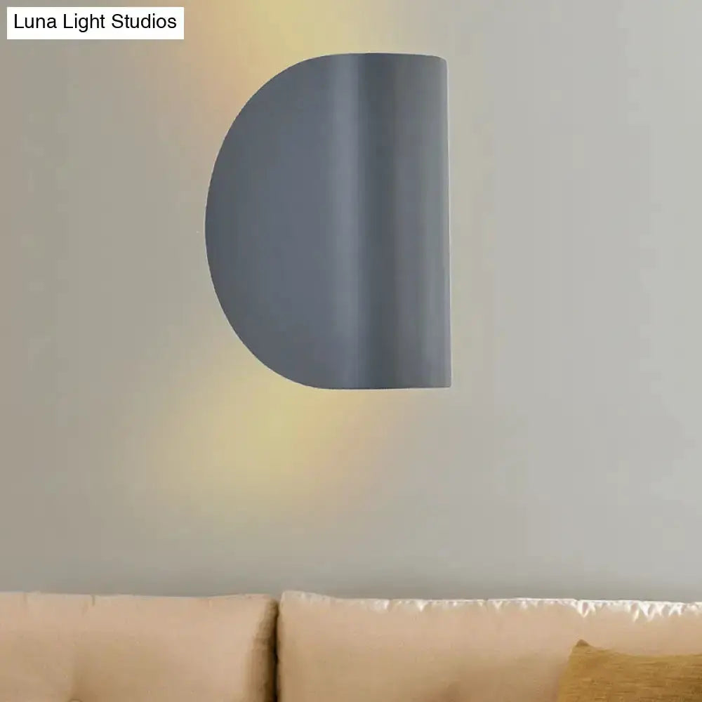 Gray curved metal wall sconce with warm ambient glow by Decorbites on Tampa Home & Garden Store
