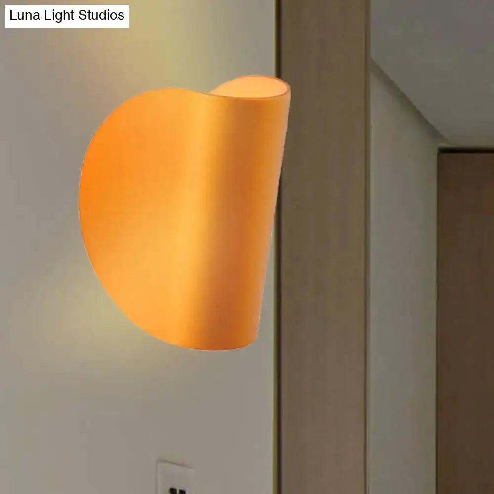 Gold curved wall sconce light with warm amber glow; Luna Light Studios watermark Decorbites on Tampa Home & Garden Store