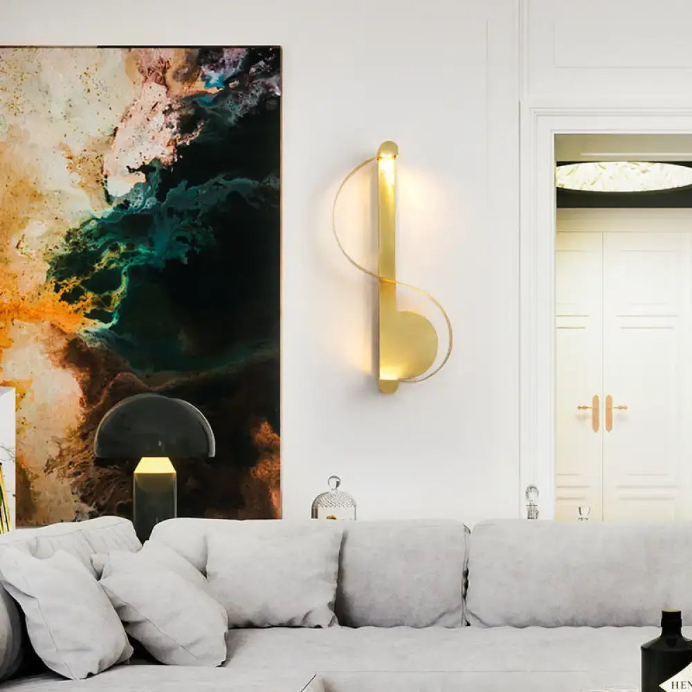 Gold curved aluminum wall sconce with ambient glow on white wall on Tampa Home & Garden Store