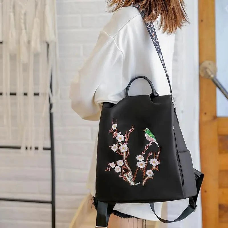 Stevvex black waterproof women's backpack with cherry blossom embroidery and a green bird on Tampa Home & Garden Store