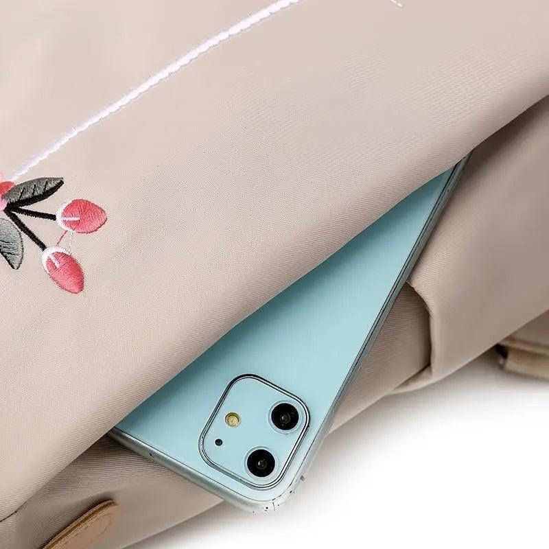 Stevvex beige waterproof backpack with anti-theft design and large capacity, teal phone peeking on Tampa Home & Garden Store