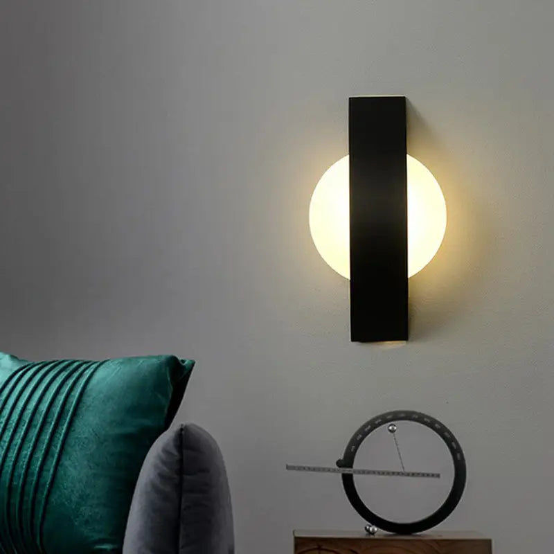 Decorbites black LED round wall sconce with vertical backplate and warm glow on Tampa Home & Garden Store