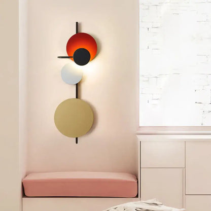 Wall sconce by Decorbites with adjustable design and red-orange, black, white, beige discs on Tampa Home & Garden Store