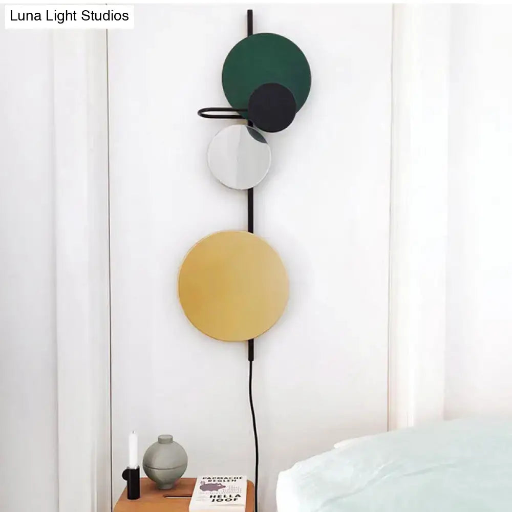 Wall sconce with vertical black rod and four discs in green, black, white, yellow; adjustable design on Tampa Home & Garden Store