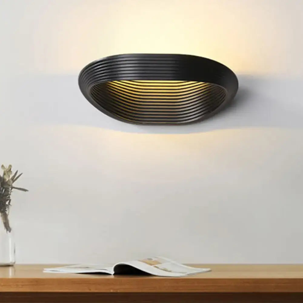 Wall light by Decorbites in black with ribbed interior shade casting warm glow on Tampa Home & Garden Store