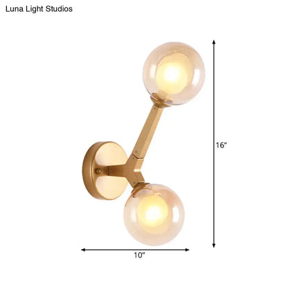 Gold amber glass wall sconce by Decorbites with dual globe shades on a brass arm wall mounted on Tampa Home & Garden Store