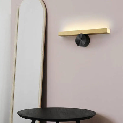 Decorbites Gold Black Linear Wall Light with warm glow and black round mounting on a gold bar on Tampa Home & Garden Store