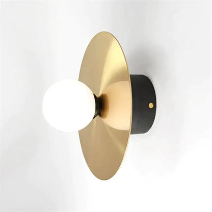Gold Black Riya Wall Light wall sconce with a gold circular backplate and white globe bulb on Tampa Home & Garden Store