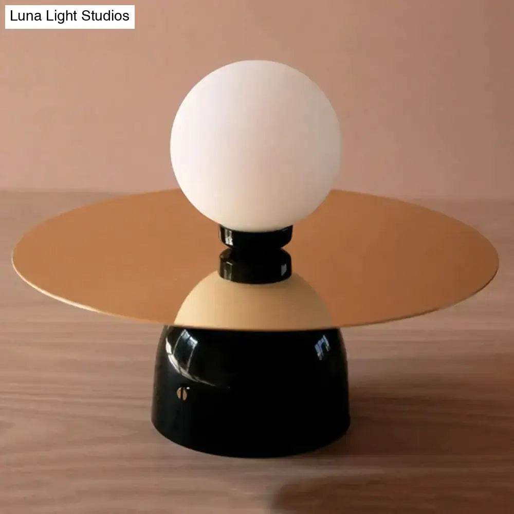 Gold Black Riya Wall Light wall sconce with white globe and gold disc shade atop black base on Tampa Home & Garden Store