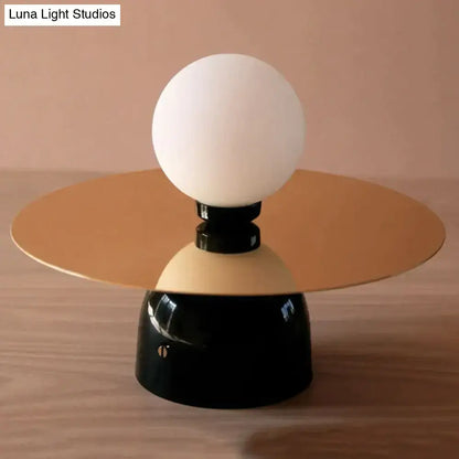 Gold Black Riya Wall Light wall sconce with white globe and gold disc shade atop black base on Tampa Home & Garden Store