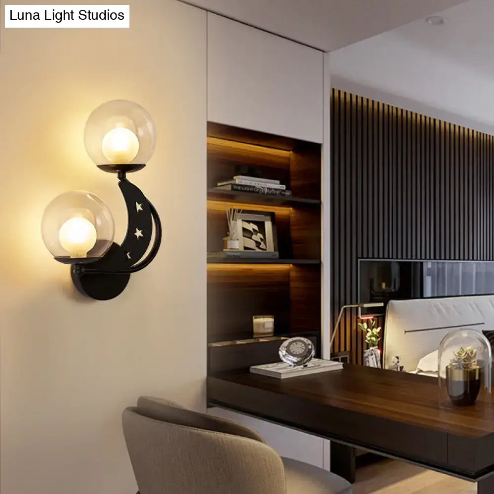 Gold Ball Wall Sconce by Decorbites with dual glass globes on a curved black mount and star accents in a modern bedroom on Tampa Home & Garden Store