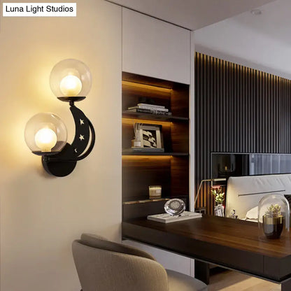 Gold Ball Wall Sconce by Decorbites with dual glass globes on a curved black mount and star accents in a modern bedroom on Tampa Home & Garden Store