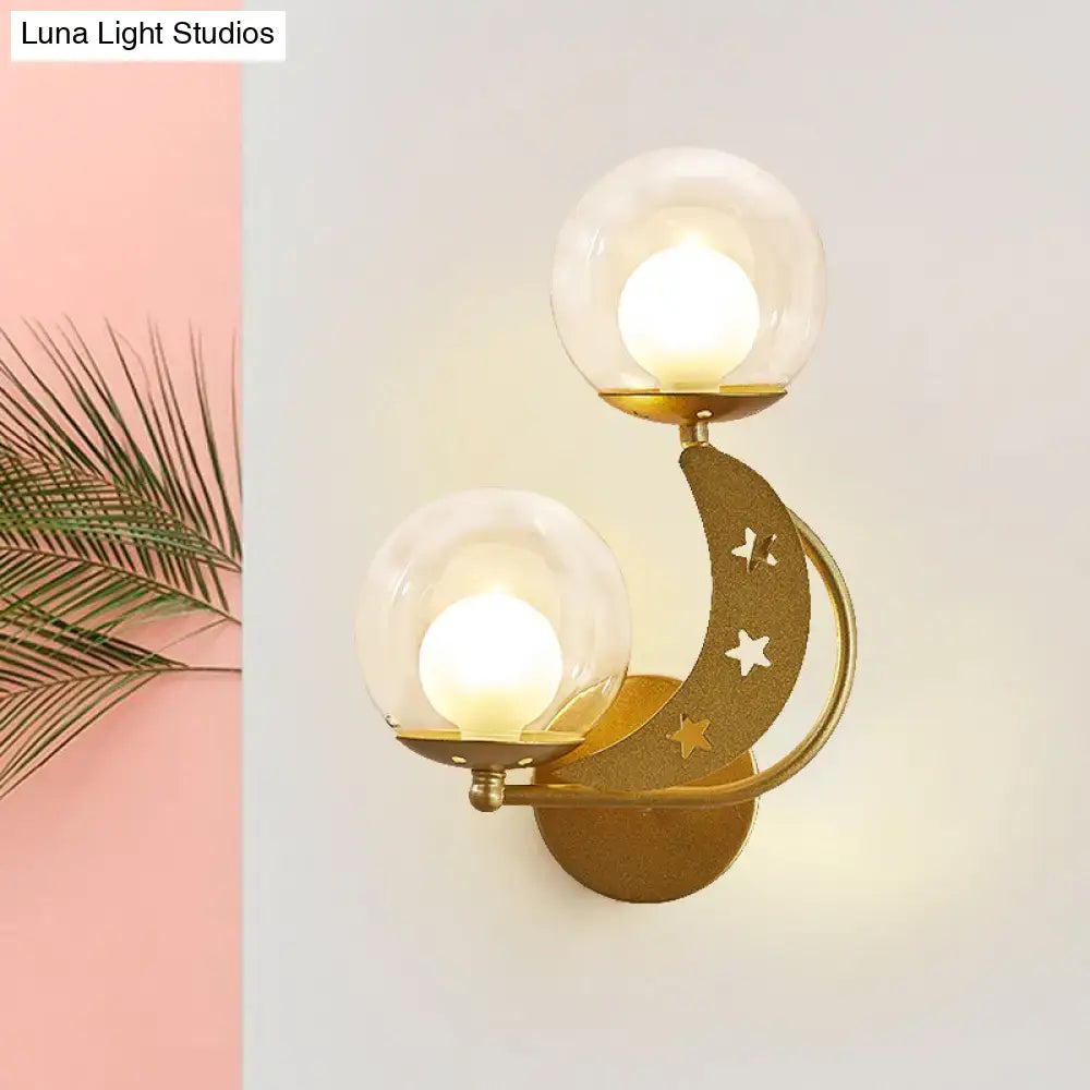 Decorbites gold ball wall sconce with dual glass globes on crescent arm and star cutouts on Tampa Home & Garden Store