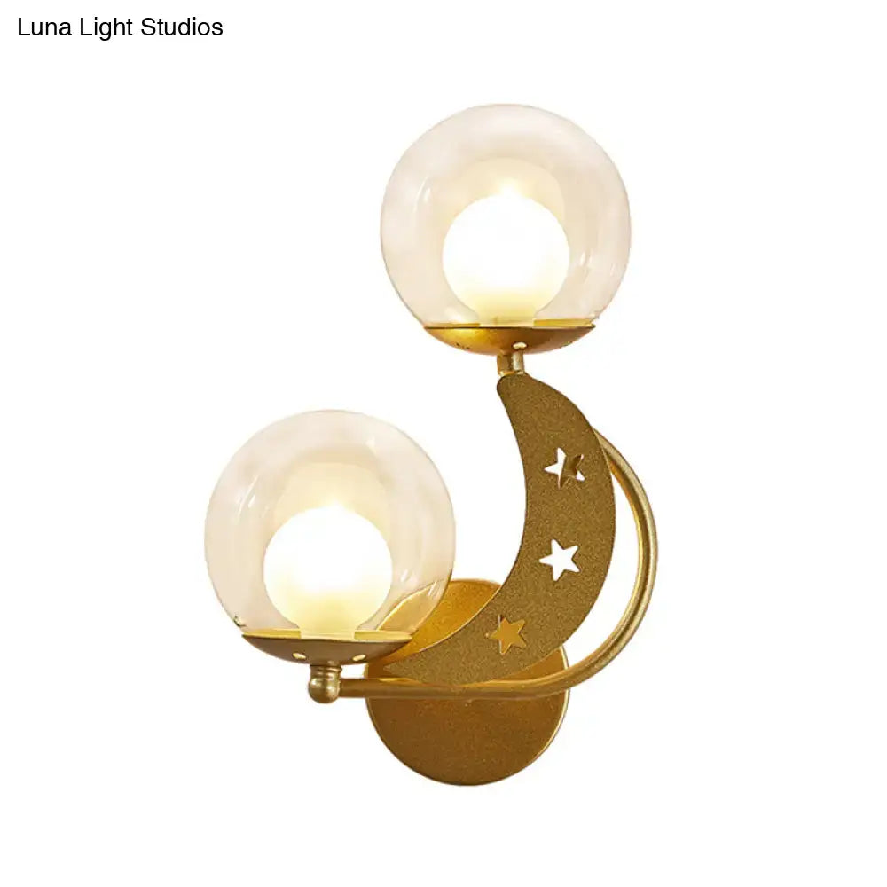 Gold ball wall sconce with twin glass globes on a curved crescent arm featuring star cutouts on Tampa Home & Garden Store