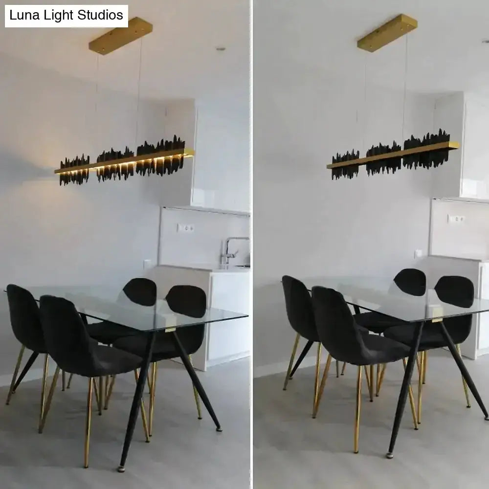 Modern gold and black iceberg LED chandelier over glass dining table with black chairs on Tampa Home & Garden Store