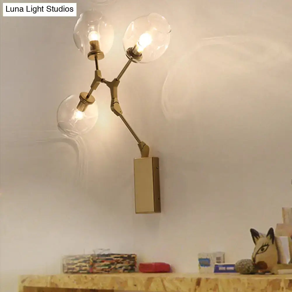 Gold branch wall sconce with three glass globe bulbs in brass finish on Tampa Home & Garden Store