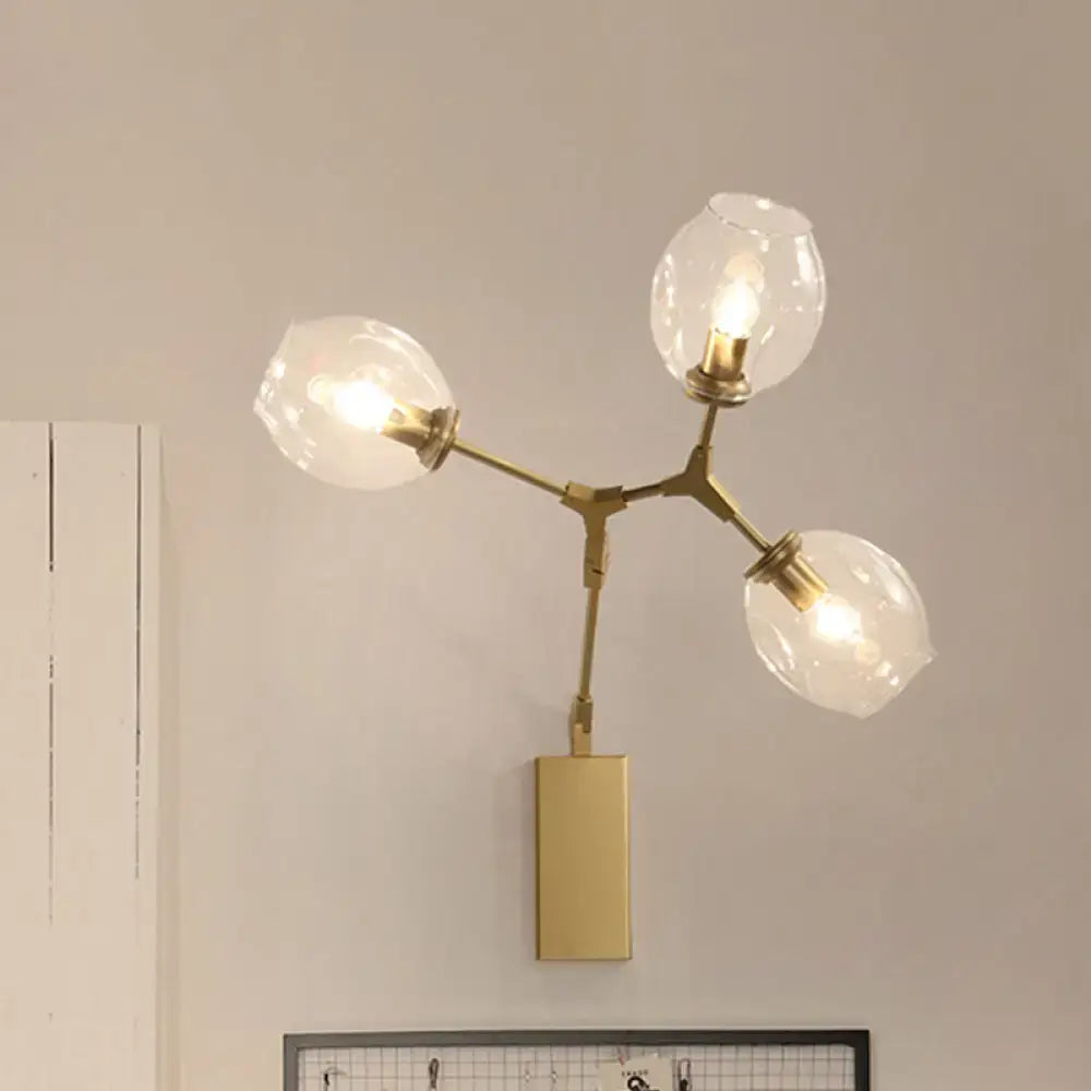 Gold branch wall sconce with four glass globe bulbs and brass arms on Tampa Home & Garden Store