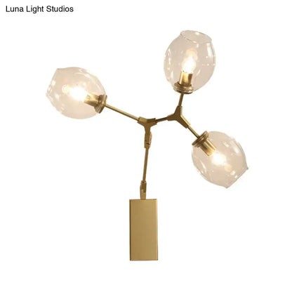Gold branch wall sconce with brass finish and three glass globe shades on Tampa Home & Garden Store