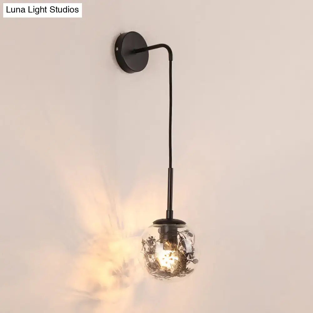 Gold glass orb wall light by Decorbites with black metal arm and round backplate on Tampa Home & Garden Store