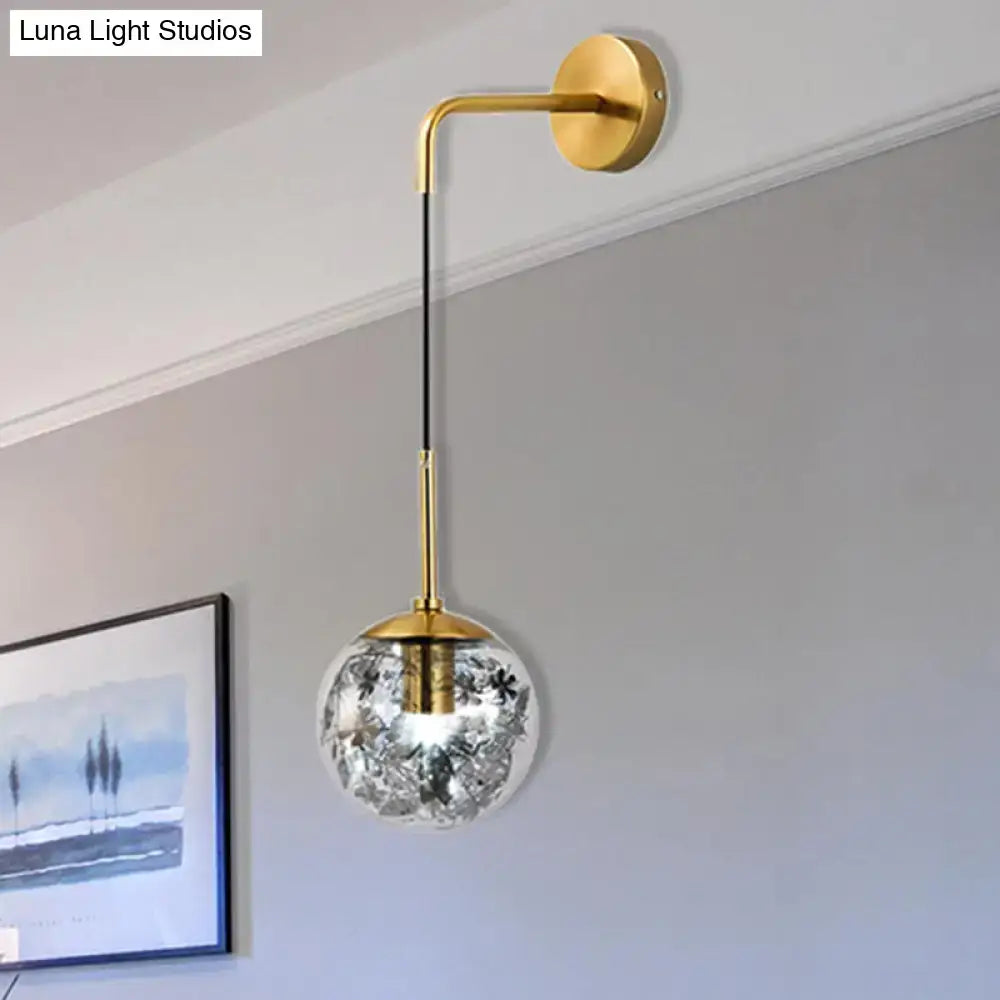Gold glass orb wall light with brass arm and etched floral globe, wall mounted on Tampa Home & Garden Store