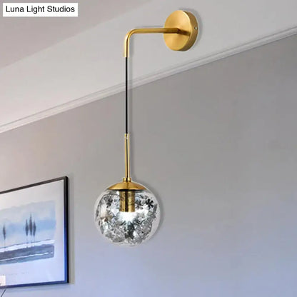Gold glass orb wall light with brass arm and etched floral globe, wall mounted on Tampa Home & Garden Store