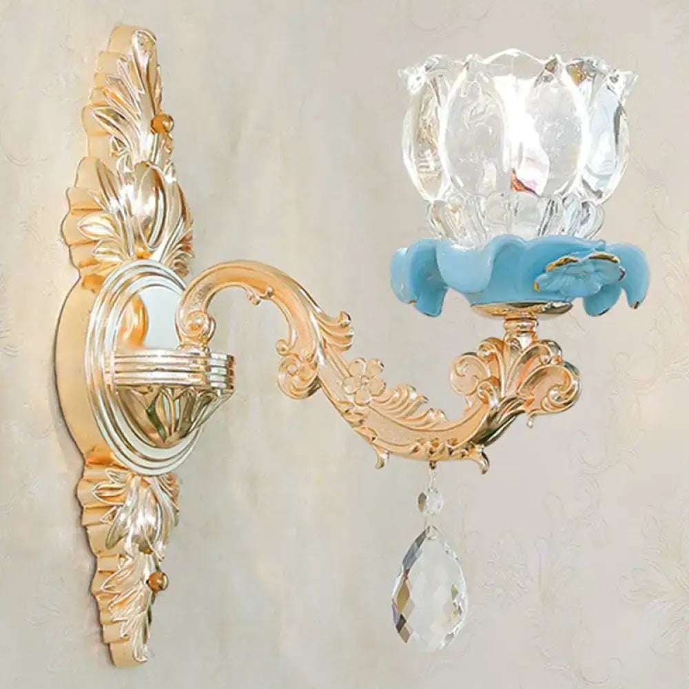 Modern gold crystal droplet wall sconce with ornate scroll arm, crystal shade, blue petal accent on Tampa Home & Garden Store