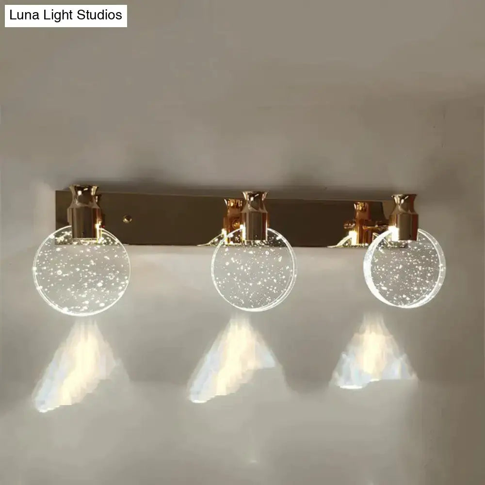 Gold three-globe wall light with brass backplate and bubble-filled glass globes by Decorbites on Tampa Home & Garden Store