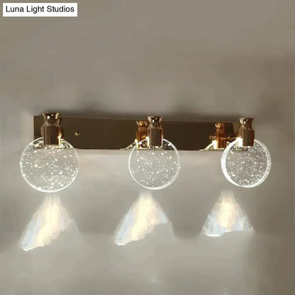 Gold three-globe wall light with bubble glass spheres and downward illumination on Tampa Home & Garden Store