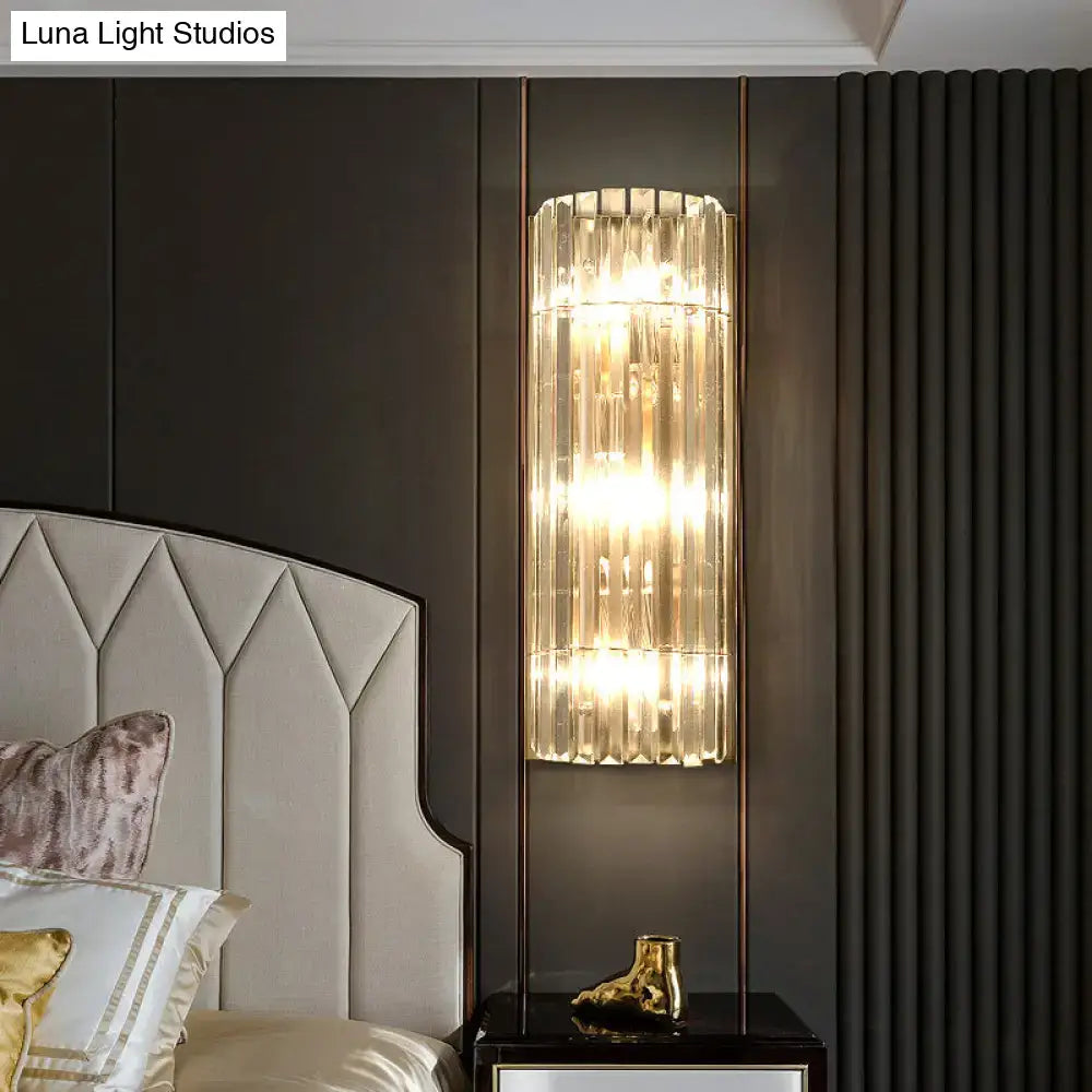 Gold crystal dining area wall sconce with vertical glass panels and warm glow on dark wall on Tampa Home & Garden Store