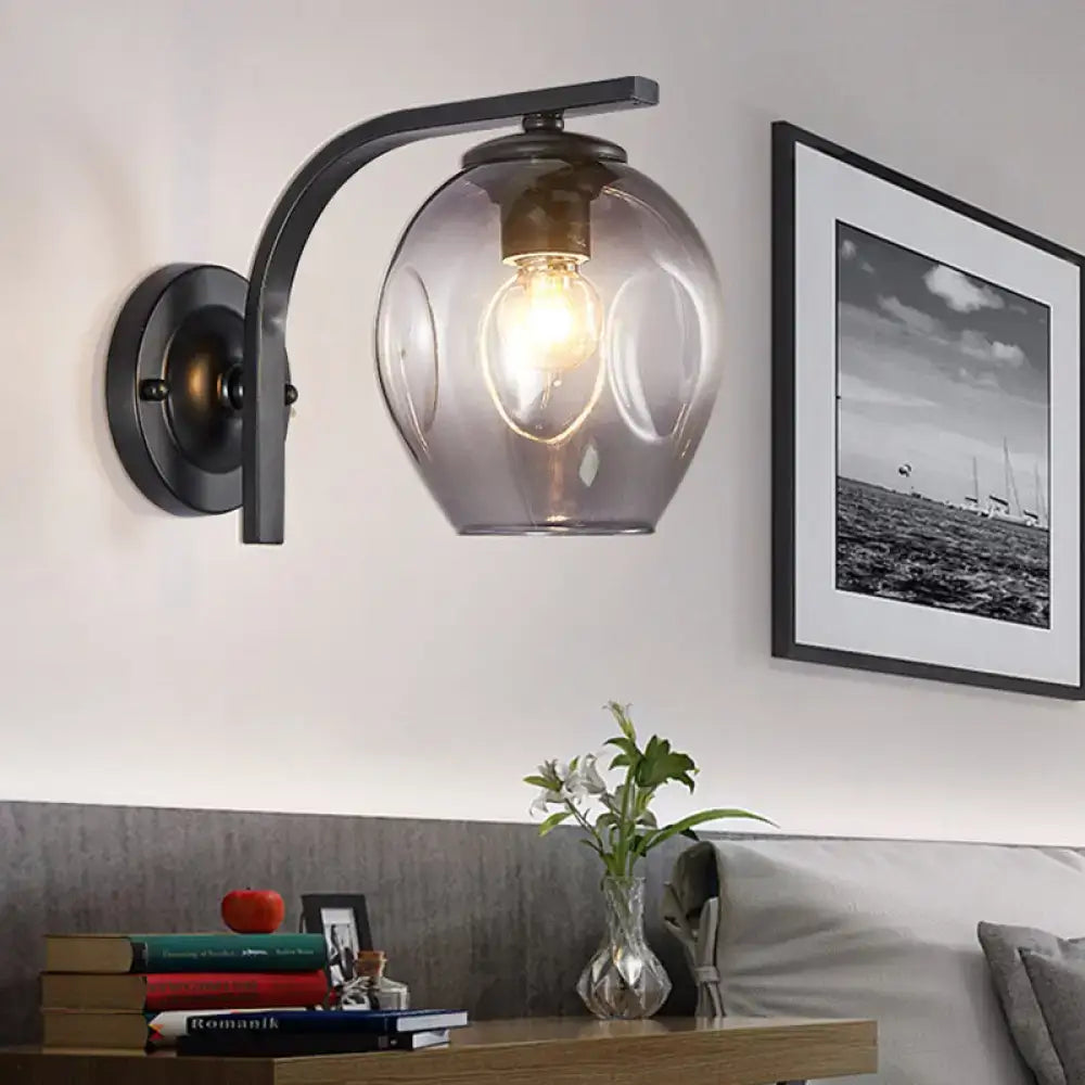 Modern curved arm glass wall sconce in dark metal with clear shade and warm bulb 1 light on Tampa Home & Garden Store