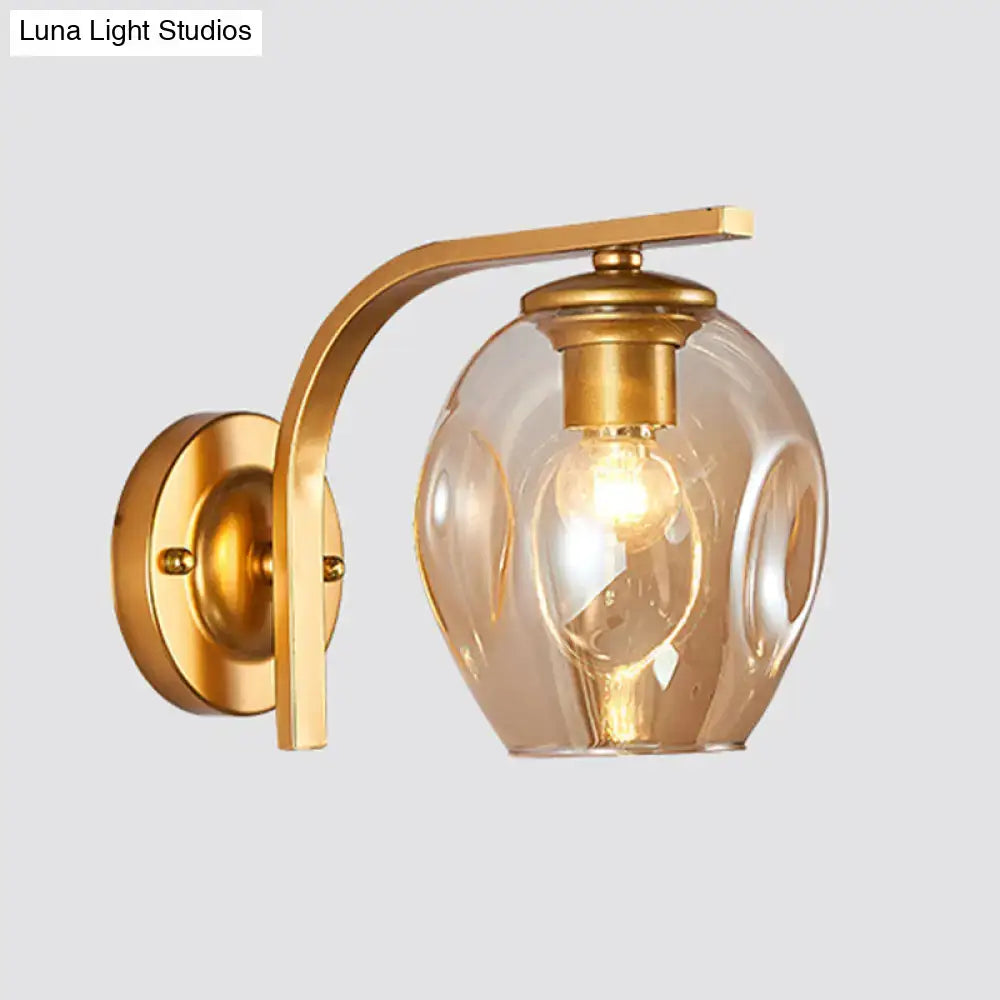 Decorbites modern gold curved arm glass wall sconce with clear glass shade on Tampa Home & Garden Store
