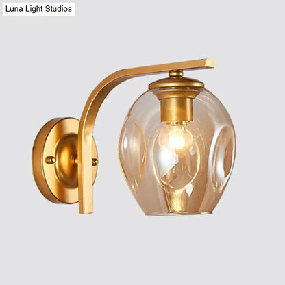 Decorbites modern gold curved arm glass wall sconce with clear glass shade on Tampa Home & Garden Store