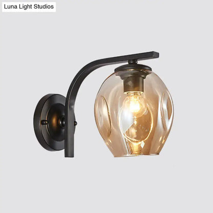 Modern gold curved arm glass wall sconce by Decorbites with black mount and amber shade on Tampa Home & Garden Store