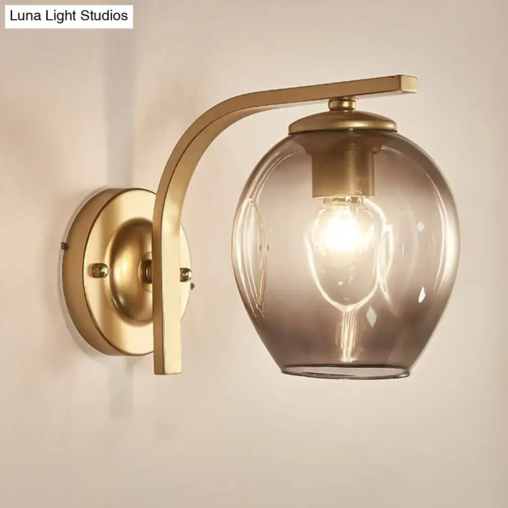 Gold curved-arm glass wall sconce with smoky glass shade for bedroom lighting by Decorbites on Tampa Home & Garden Store