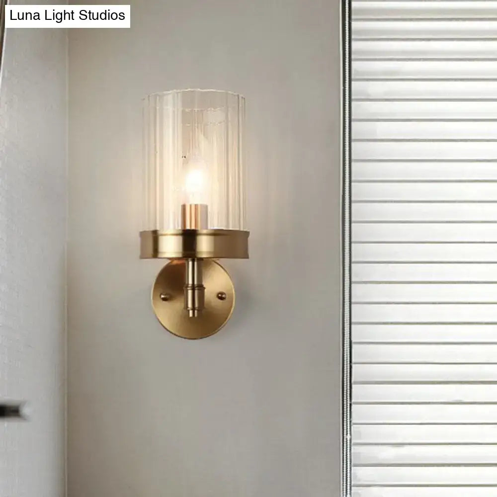 Gold finish minimalist hallway sconce with clear cylindrical glass shade and brass mount on Tampa Home & Garden Store