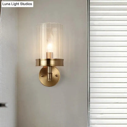 Gold finish minimalist hallway sconce with clear cylindrical glass shade and brass mount on Tampa Home & Garden Store