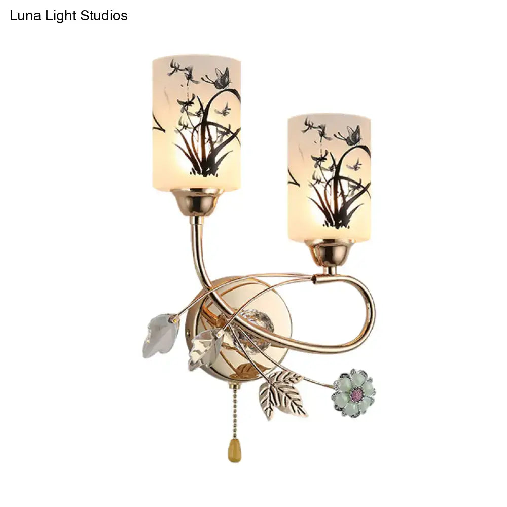 Gold floral cast iron wall sconce with two ivory glass shades and crystal accents on Tampa Home & Garden Store